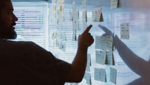 Leader reviewing strategy notes on a wall filled with sticky notes during a planning session