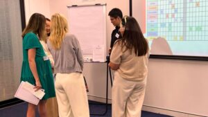 Group of professionals gathered around a flip chart working through a real scenario during a leadership workshop